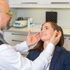 Dr. Peter Neumann analysiert die Nase einer Patientin
